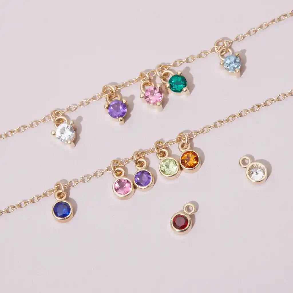 Birthstone charms styled and layered to show personalized birthstone jewelry