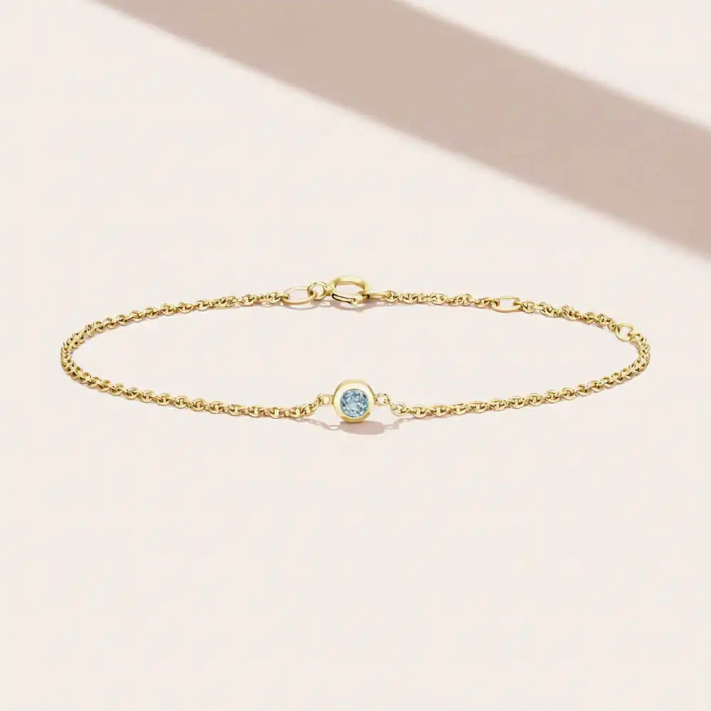 Bezel-set aquamarine birthstone bracelet. silver variant--14K-yellow-gold variant--Aquamarine