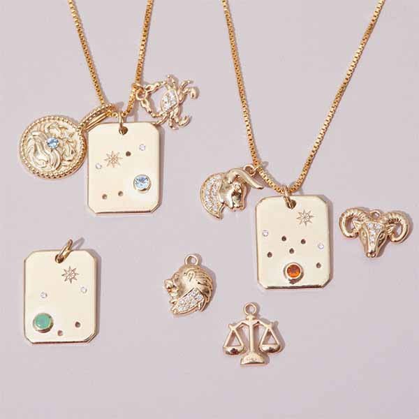 constellation necklace styled with other gold zodiac charms