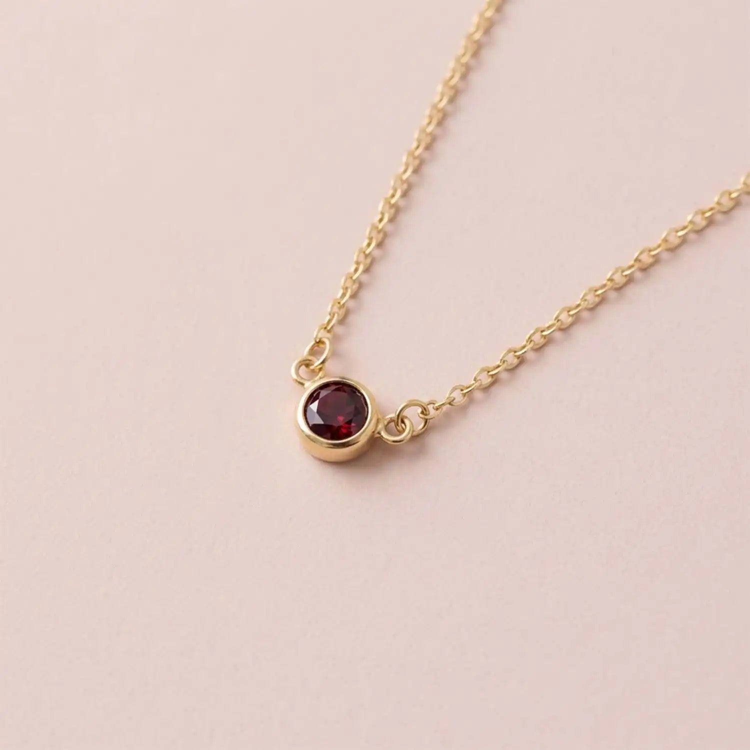 Bezel-set garnet birthstone necklace in 14K yellow gold on cable chain variant--Sterling silver