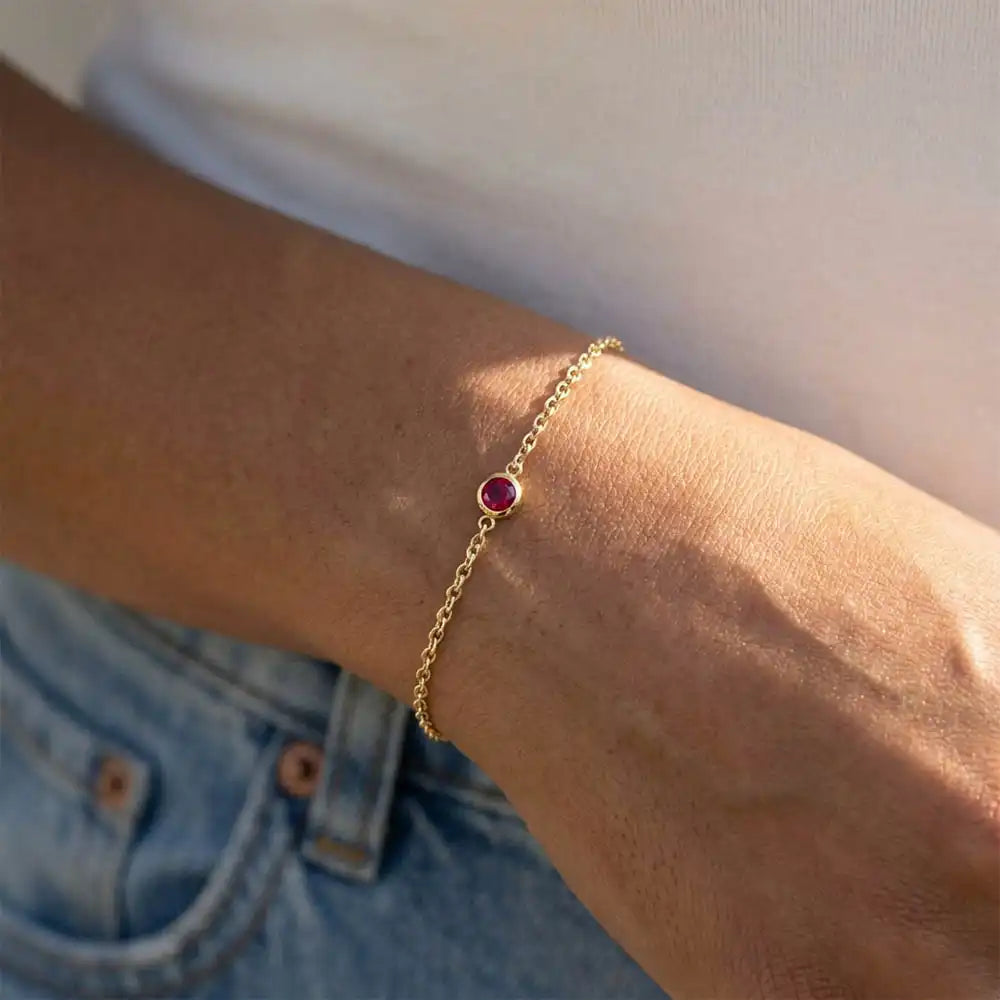 Model wearing bezel-set ruby bracelet. variant--14K-yellow-gold variant--Ruby