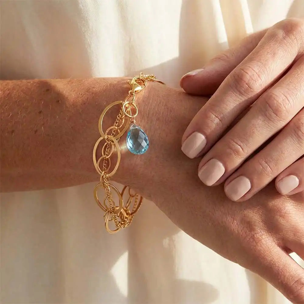Natural swiss blue topaz woven chain bracelet in sterling silver, close-up of setting in gold-fill