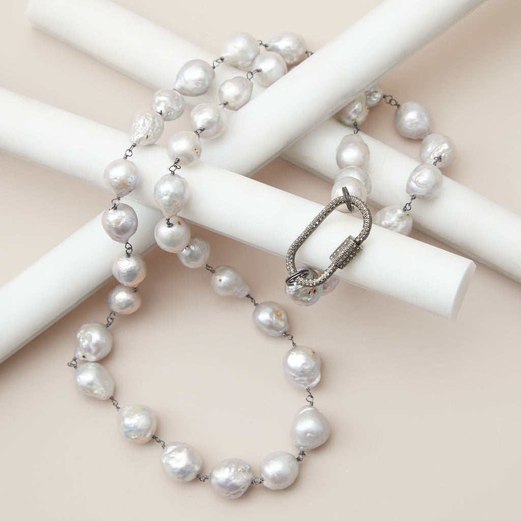 Flat lay of baroque pearl rope necklace with diamond clasp