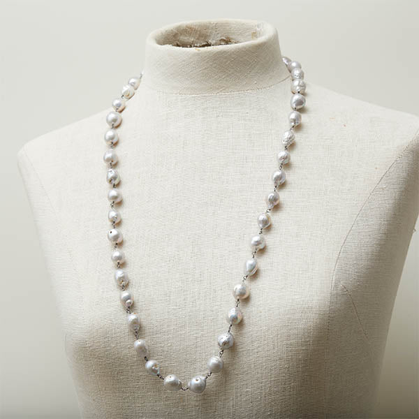 Long baroque pearl necklace worn as a statement piece