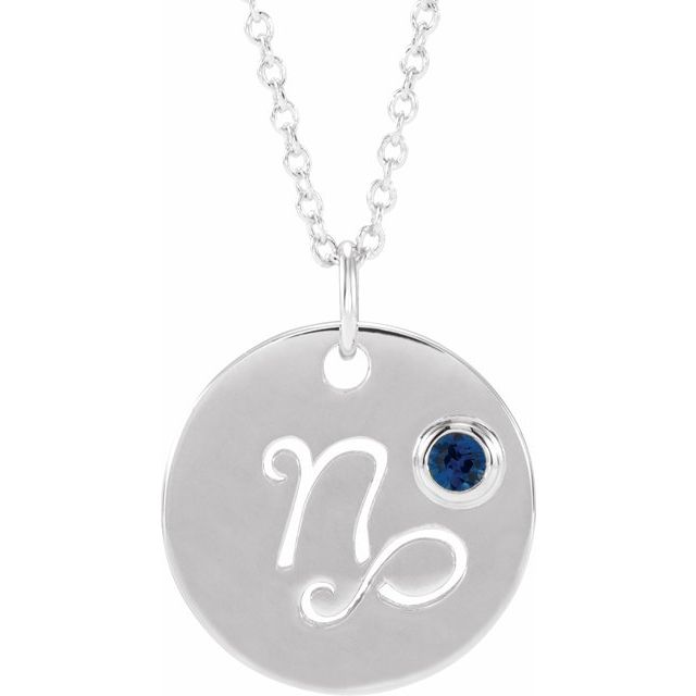 Silver necklace with capricorn symbol and sapphire gemstone on a white background