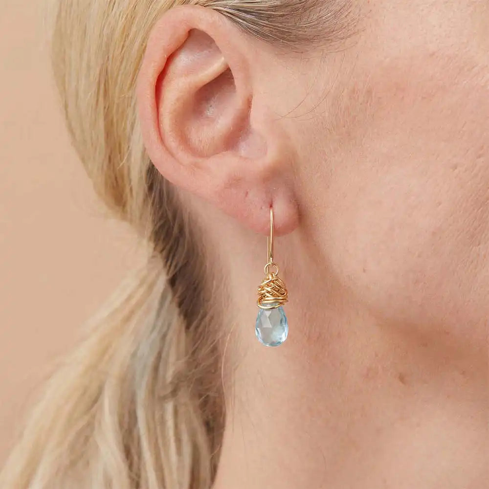 Close-up of natural aquamarine bezel dangle earring, showing soft blue stone and handcrafted wire detail variant--Gold-fill variant--Sterling-silver variant--Aquamarine