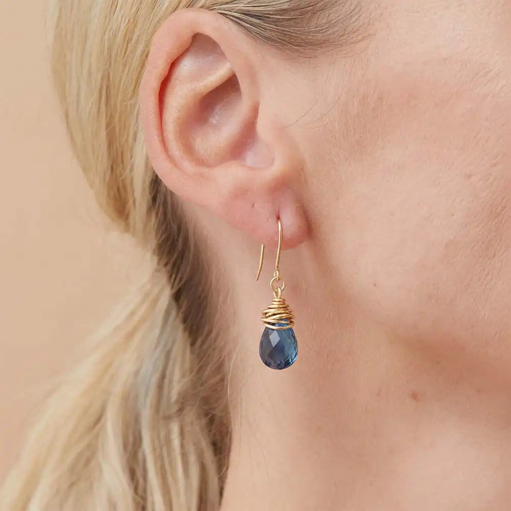 Close-up of natural london blue topaz bezel dangle earring, showing saturated inky blue stone and handcrafted detail. variant--Gold-fill variant--Sterling-silver variant--London-Topaz