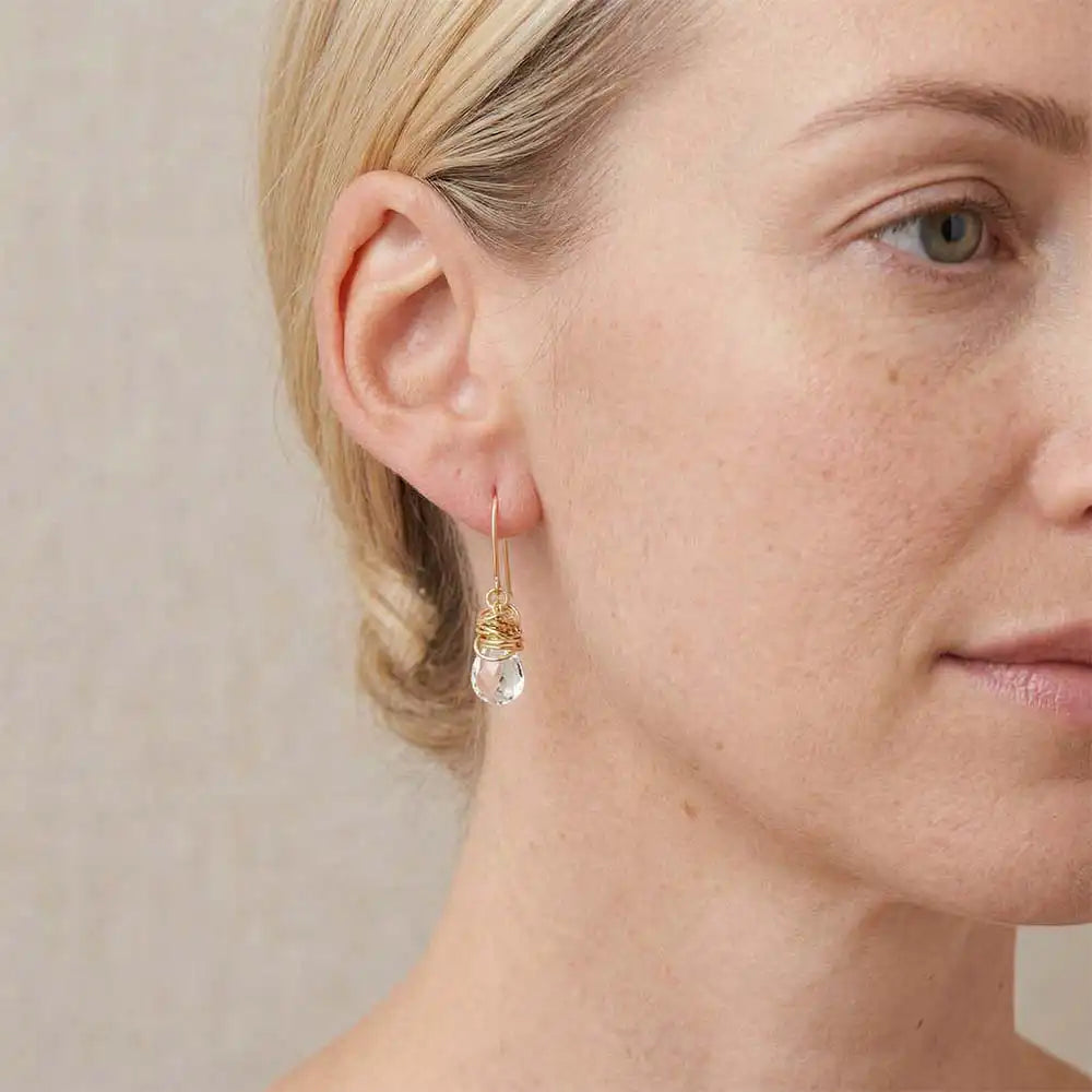 Close-up of natural white topaz bezel dangle earring, showing brilliant clear stone and handcrafted detail variant--Gold-fill variant--Sterling-silver variant--White-topaz