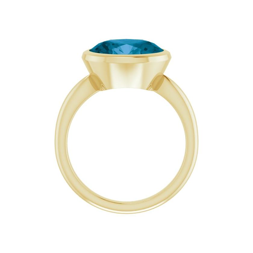 Sustainable topaz ring crafted in yellow gold, oval gemstone set across the band