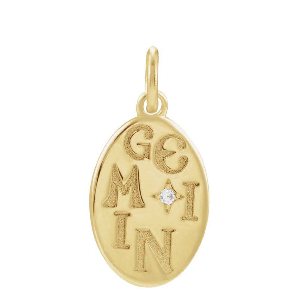 Close-up of hand-engraved Gemini glyph on gold charm