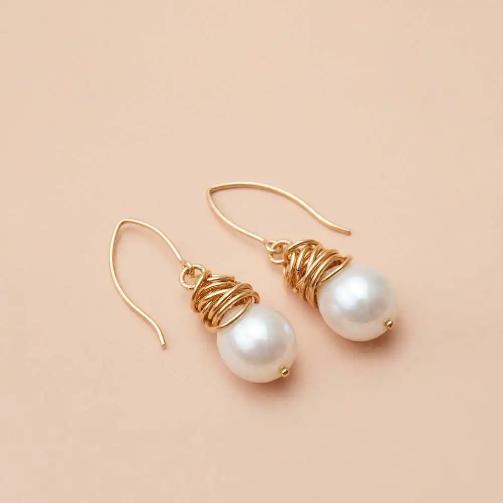 Pearl dangle earrings product shot, genuine freshwater pearl in sculptural bezel setting on model variant--Gold-fill variant--Sterling-silver variant--Pearl