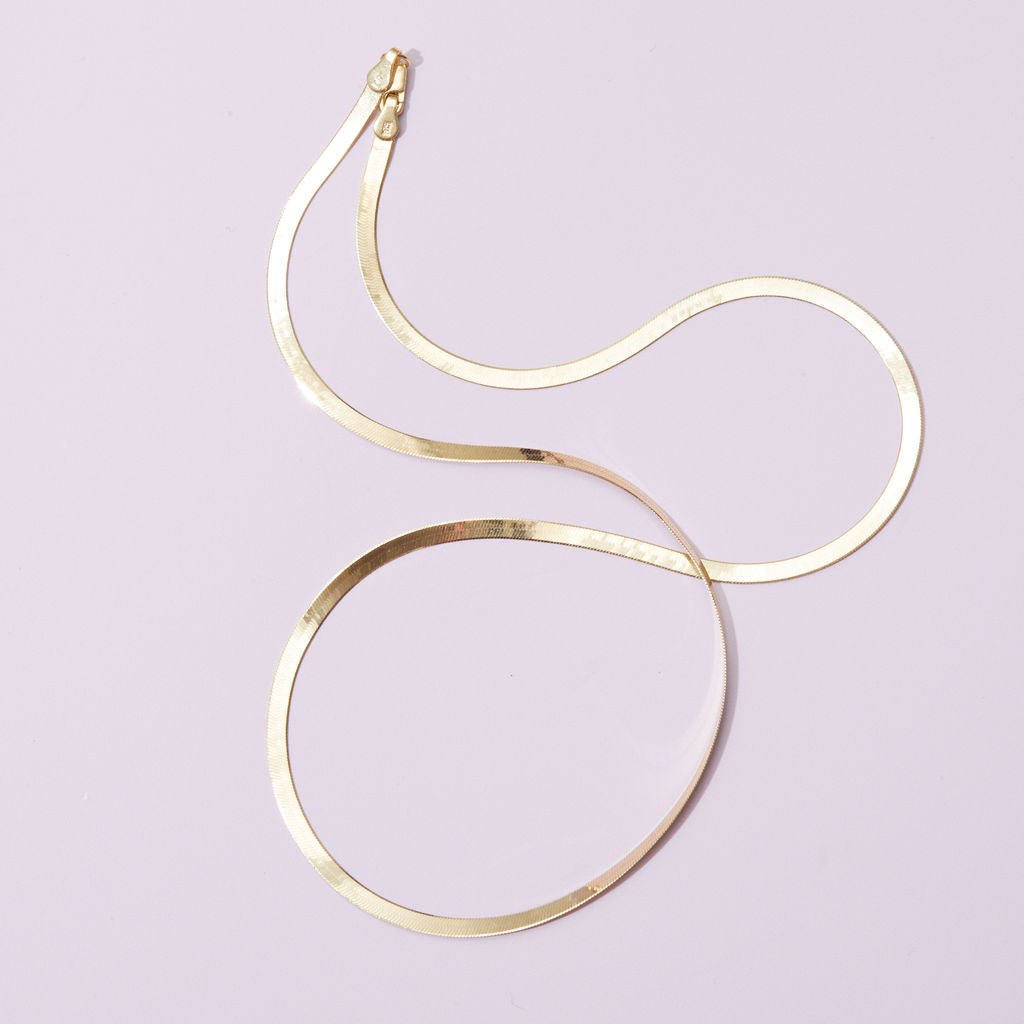 14k gold herringbone chain styled casually for everyday wear.