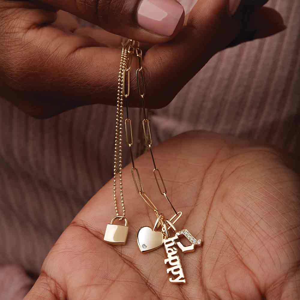 Personalized lock charm necklaces stacked with dainty chains