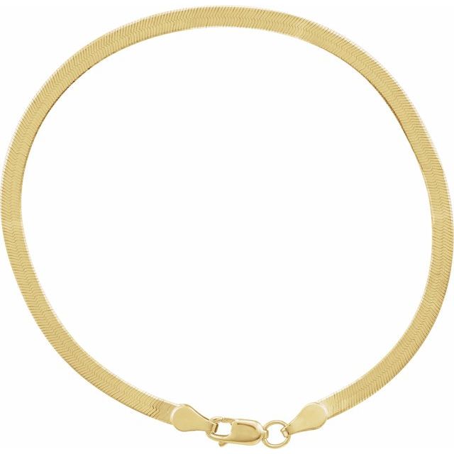 Close-up of herringbone necklace texture showing interwoven gold links.