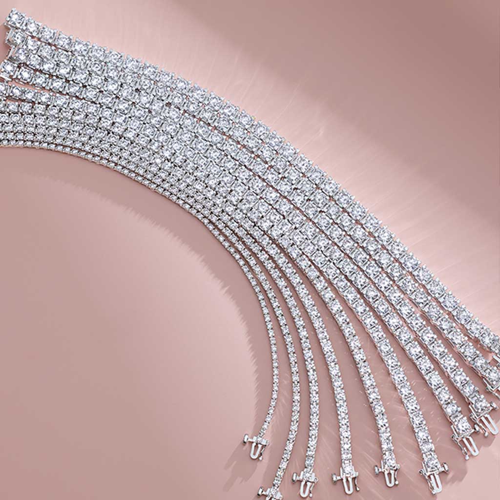 Layered tennis bracelets in white gold on neutral background