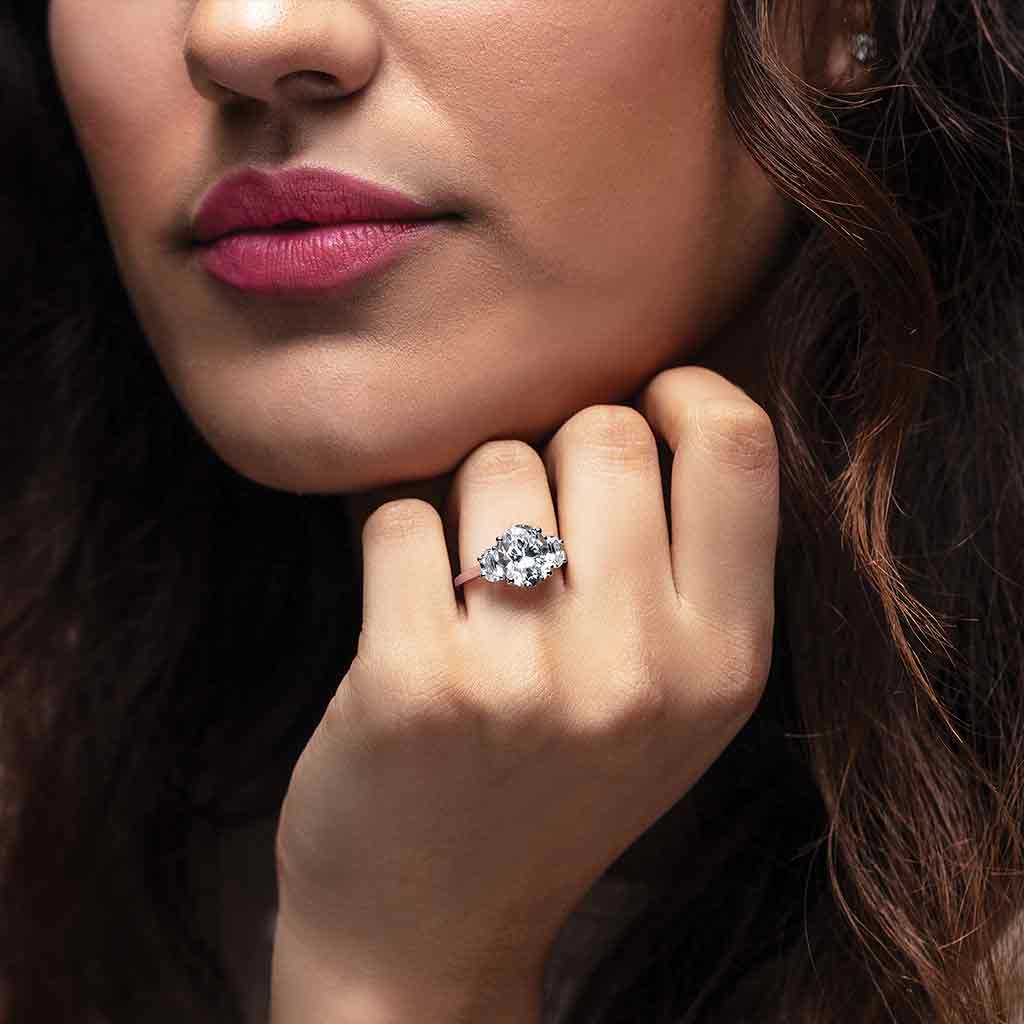 Three-stone half-moon engagement ring in 14K gold, diamond center, on hand