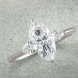 Three-stone engagement ring with pear side stones in 14K gold, diamond center, side profile