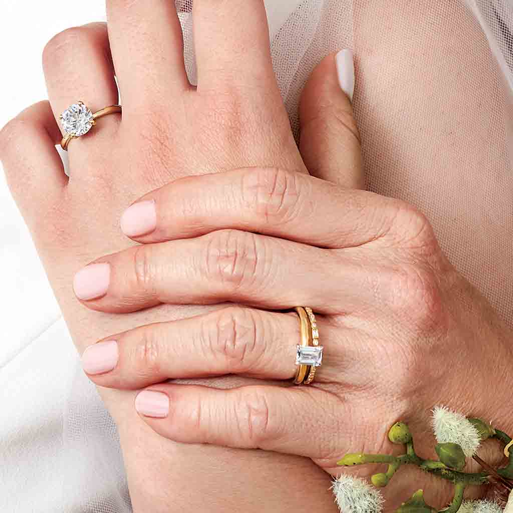 Gold eternity band with mixed diamond shapes shown on model