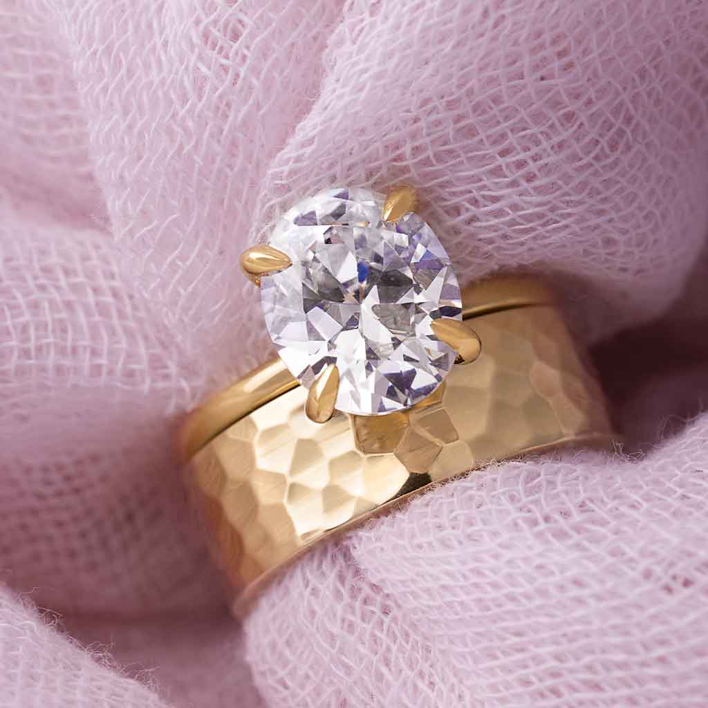 Oval diamond Claw-prong solitaire engagement styled with wide wedding band