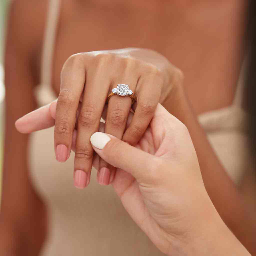 Three-stone engagement ring with round side stones in 14K gold, diamond center, side profile