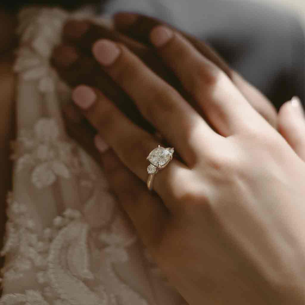 Three-stone engagement ring with round side stones in 14K gold, diamond center, side profile
