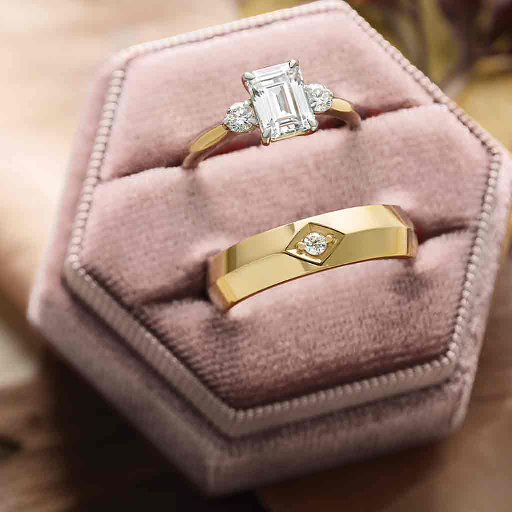 Three-stone engagement ring with round side stones in 14K gold, diamond center, overhead