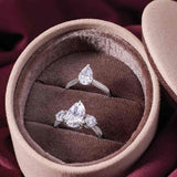 Three-stone engagement ring with round side stones in 14K gold, pear center, in packaging