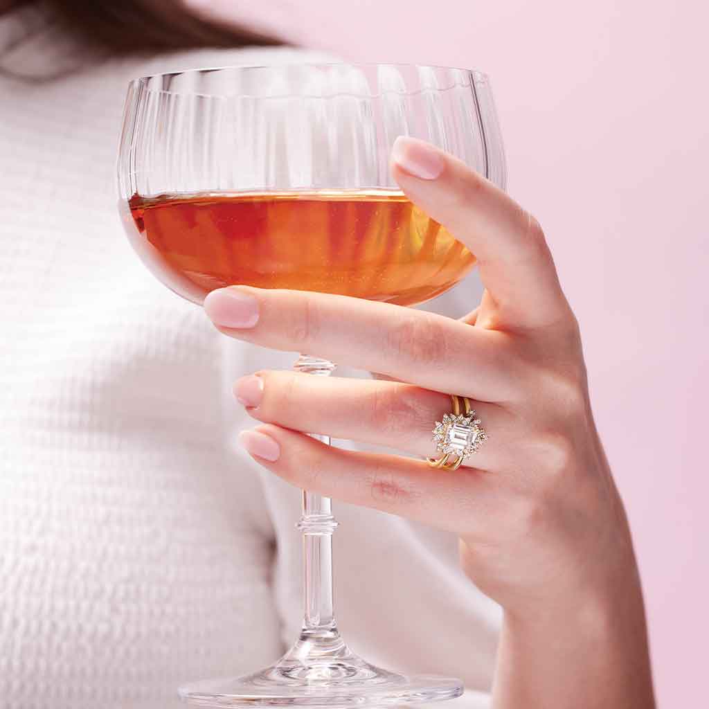 Floral halo engagement ring with oval center on model