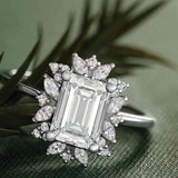 Floral halo diamond engagement ring with emerald-cut center in 14K gold, editorial view