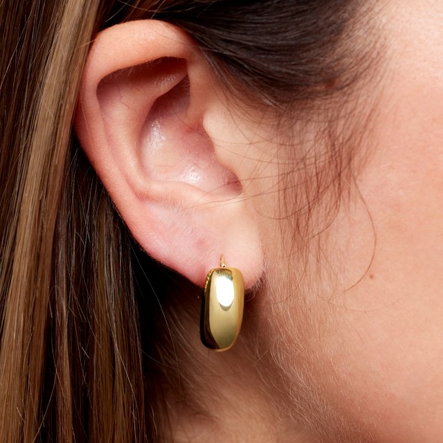 Gold huggy hoop earrings showing levered catch closure detail