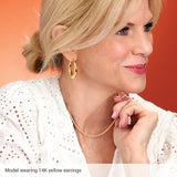 Large puffy hoop earrings in 14K gold, on model showing scale