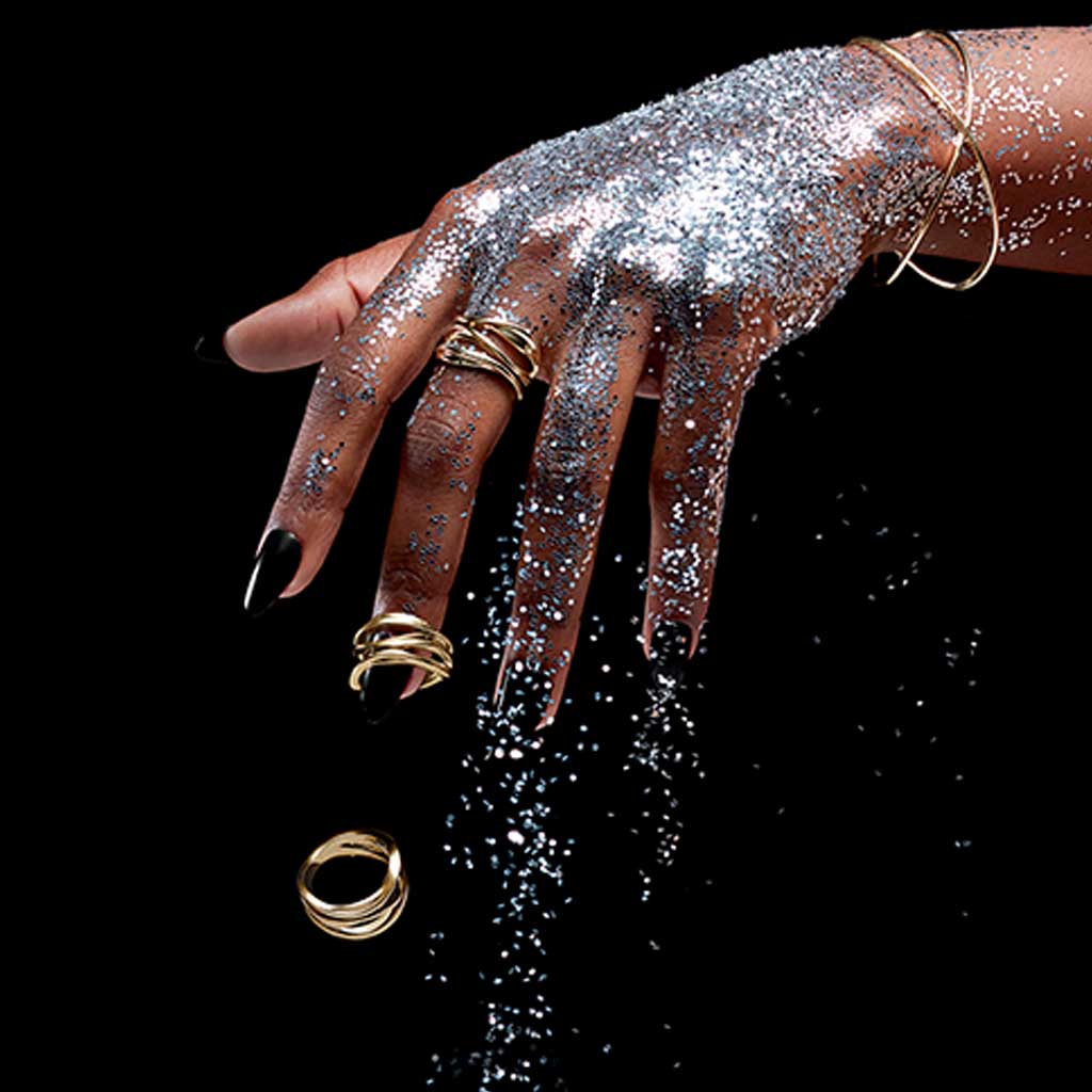 Gold wave ring on hand, showing sculptural wave profile
