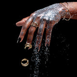 Gold wave ring on hand, showing sculptural wave profile
