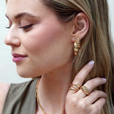 Gold wave ring on model, styled close-up showing width