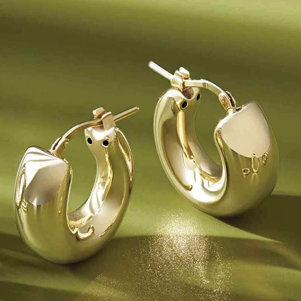 Solid 14K gold huggy hoop earrings, editorial styling view