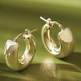 Solid 14K gold huggy hoop earrings, editorial styling view