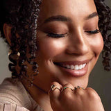 Gold huggy hoop earrings on model, close-up side view