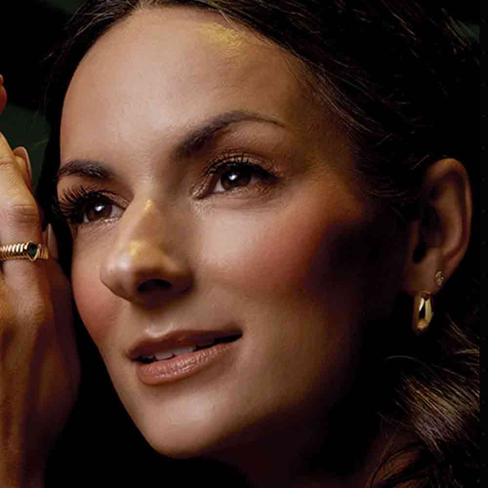 Gold huggy hoop earrings on model, second angle