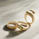 Peridot teardrop ring, editorial styling on surface