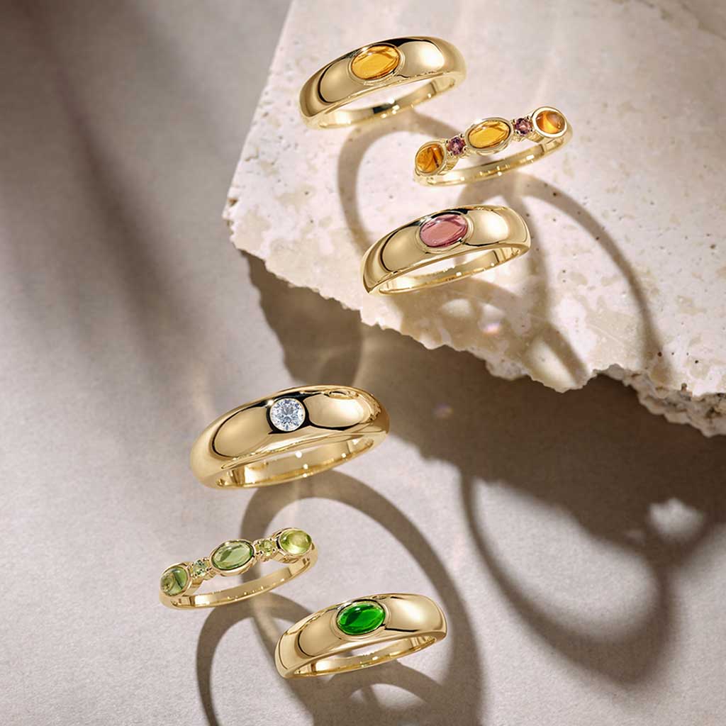 Yellow gold diamond dome ring styled with other rings