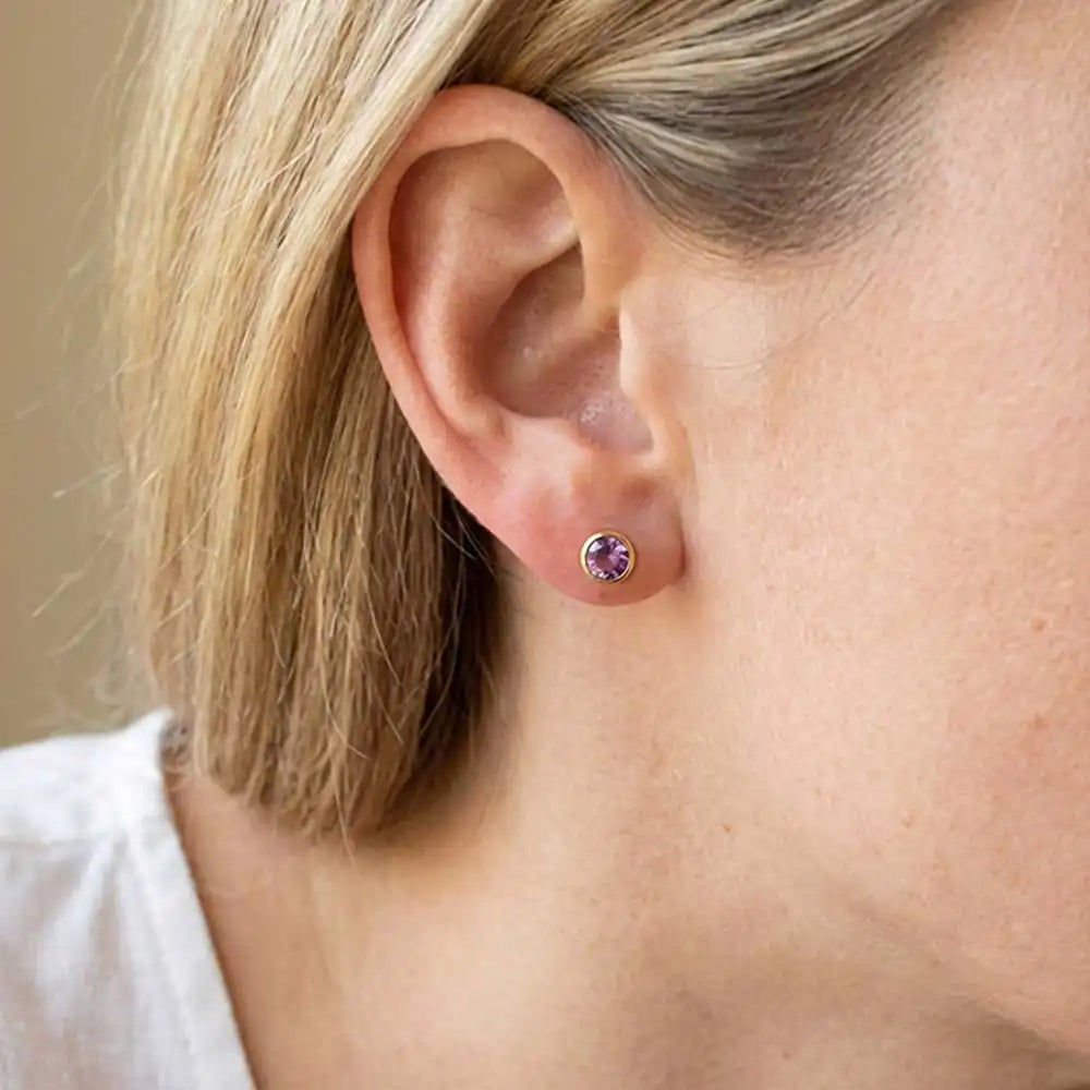Amethyst birthstone stud earrings on model, soft violet studs at ear