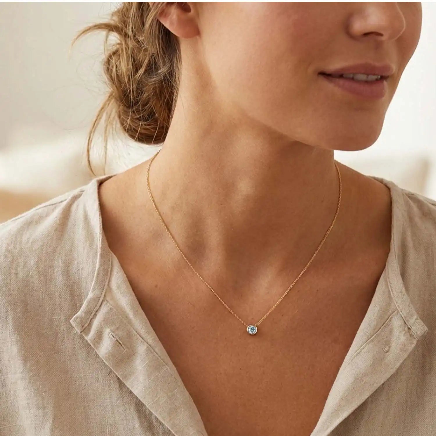 Bezel-set aquamarine necklace on model, layered at the collarbone