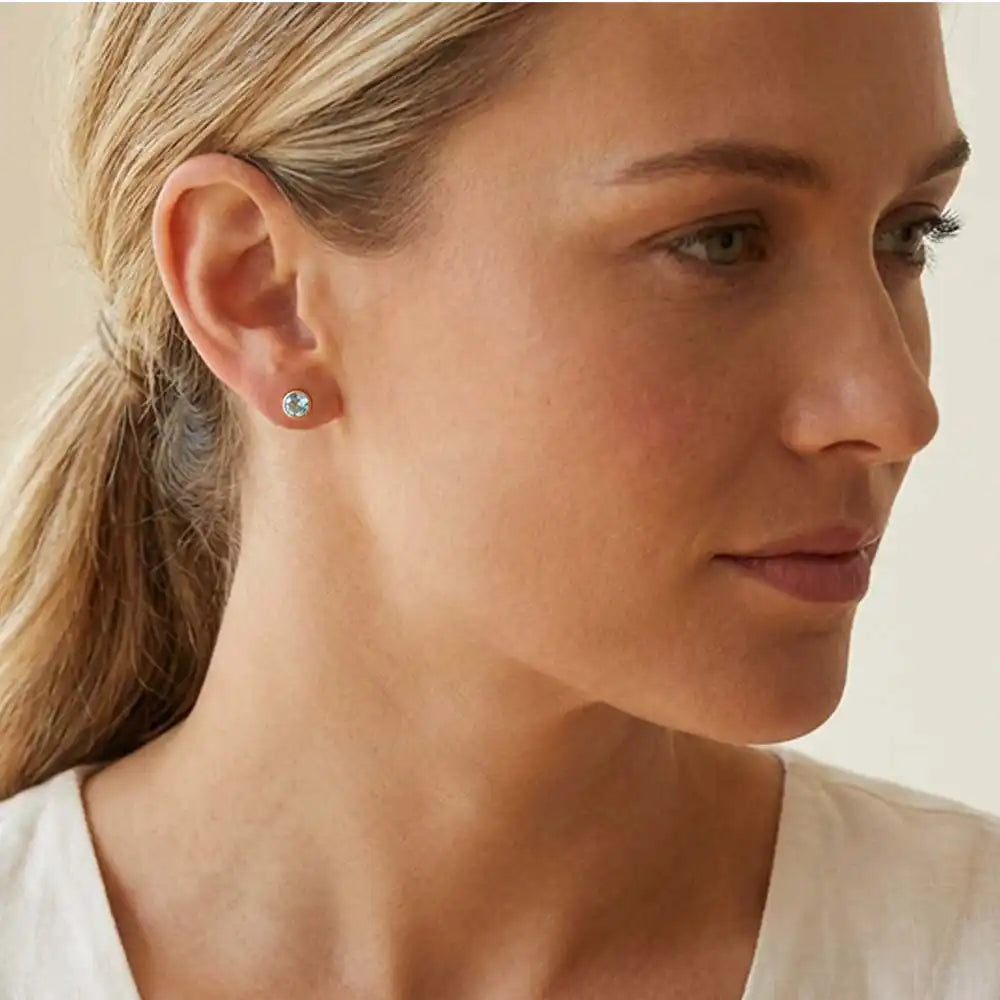 Aquamarine birthstone stud earrings on model, pale blue studs at ear