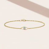 Bezel-set aquamarine birthstone bracelet. silver variant--14K-yellow-gold variant--Aquamarine