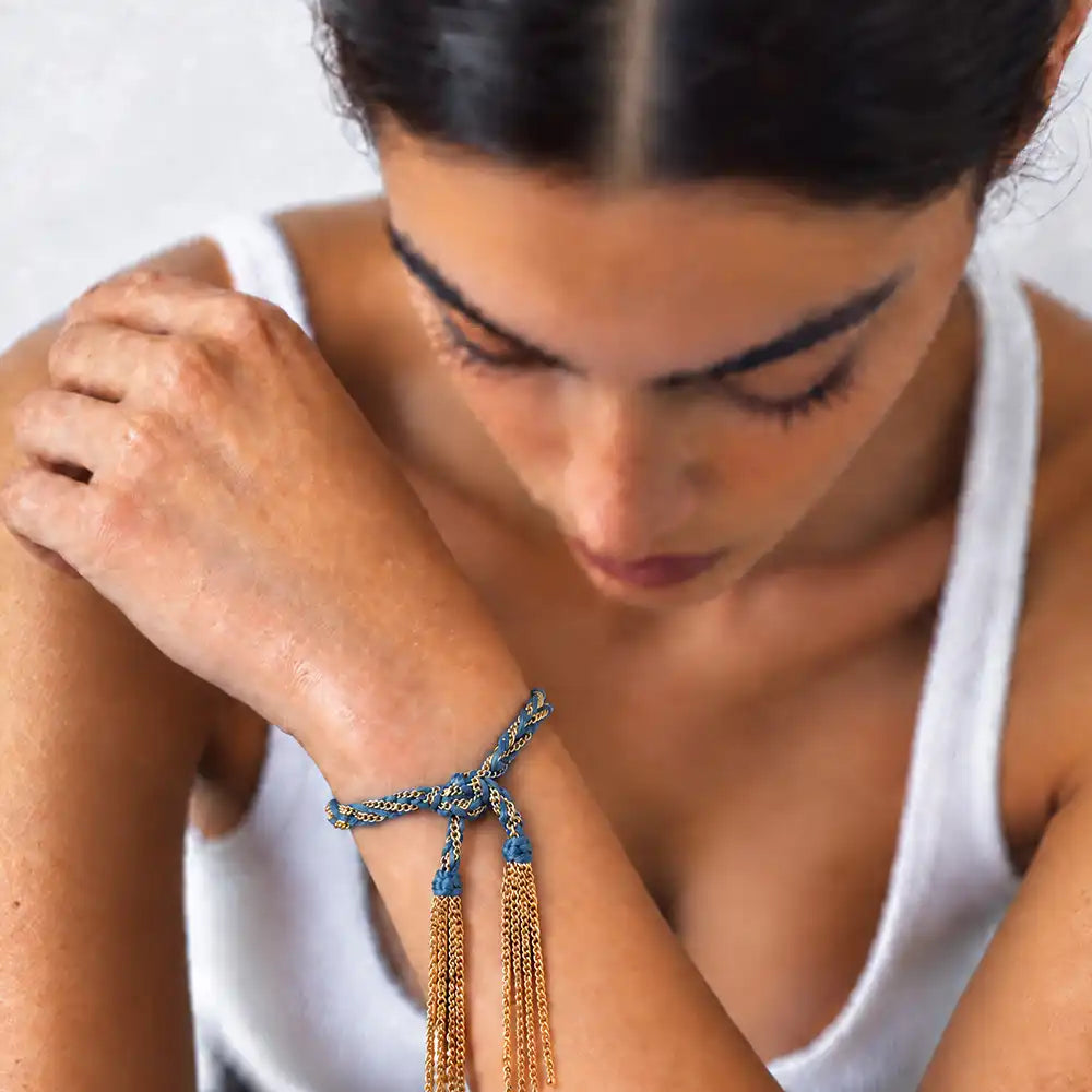 Blue braided chain and silk tassel bracelet in 14K gold-fill worn on model