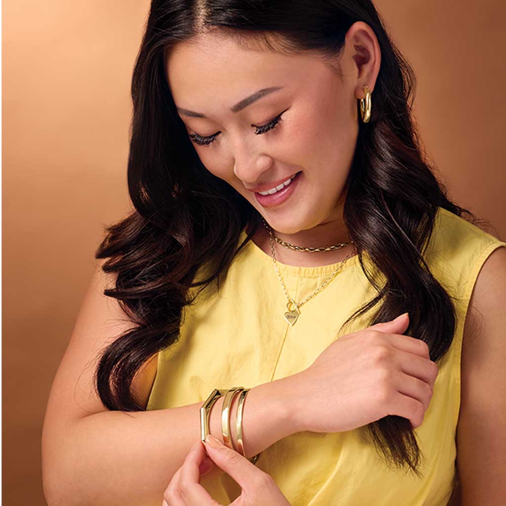 Hinged bangle bracelet on model, showing polished gold finish