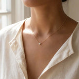Bezel-set lab-created diamond necklace on model, layered at the collarbone