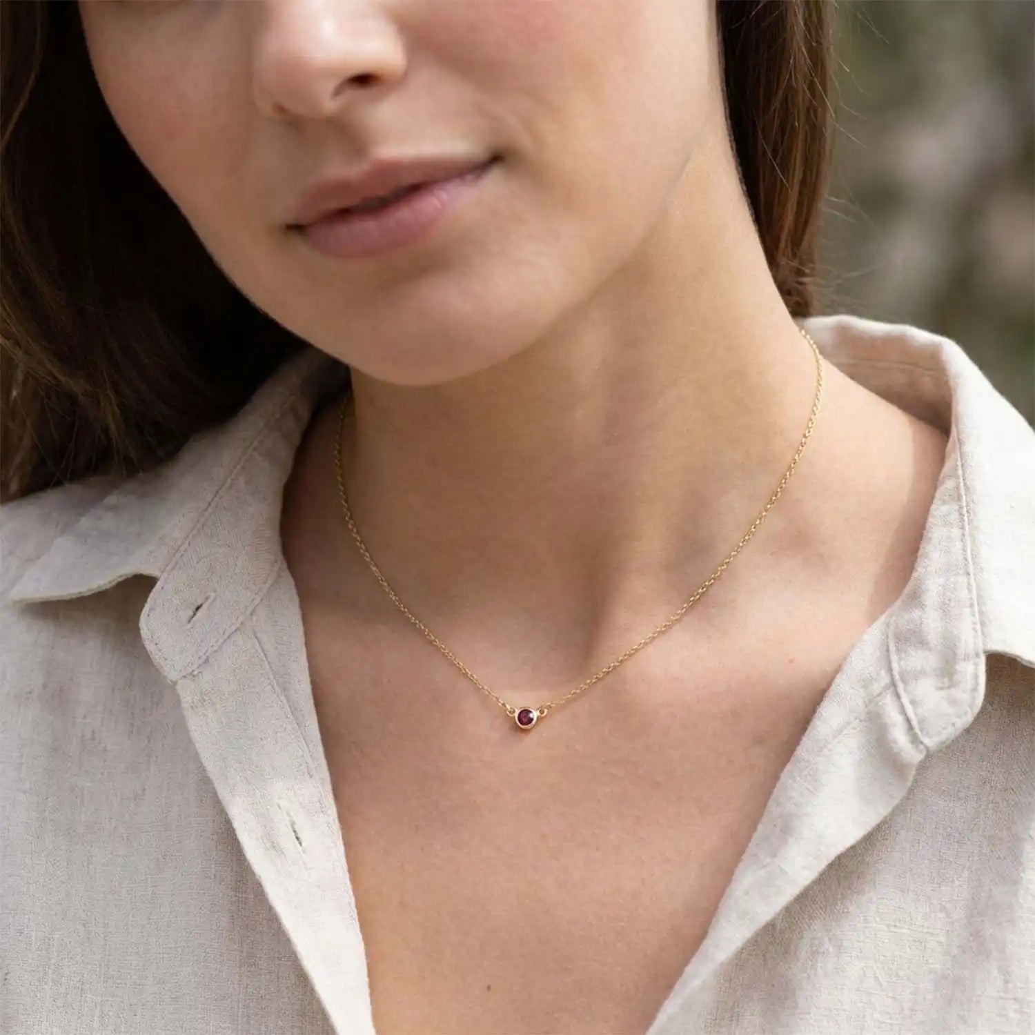 Bezel-set garnet necklace on model, layered at the collarbone variant--14K yellow gold