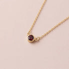Bezel-set garnet birthstone necklace in 14K yellow gold on cable chain variant--Sterling silver