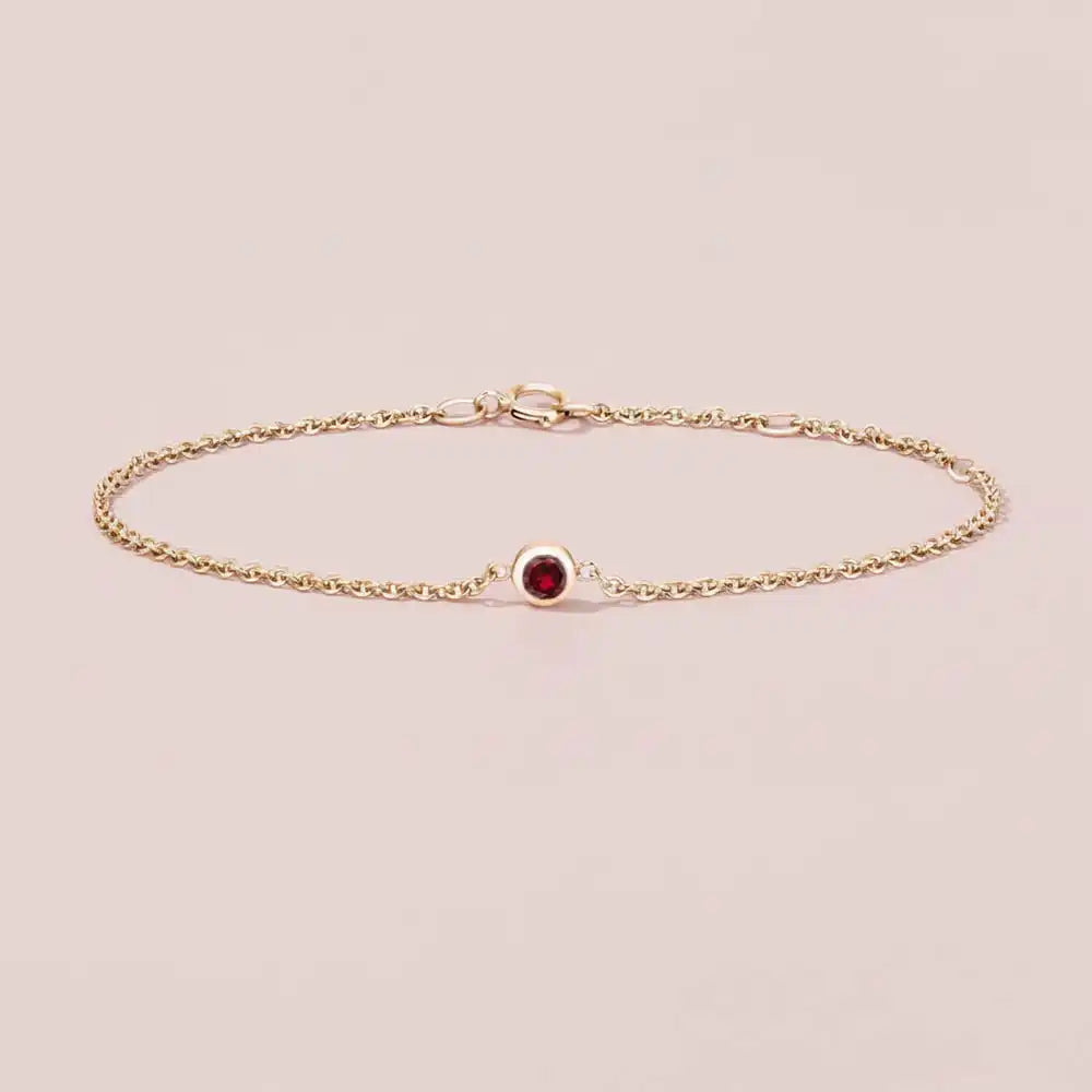 Bezel-set garnet bracelet in 14K yellow gold on adjustable curb chain